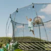 Kluk si hraje na supermana na trampolíně Springfree