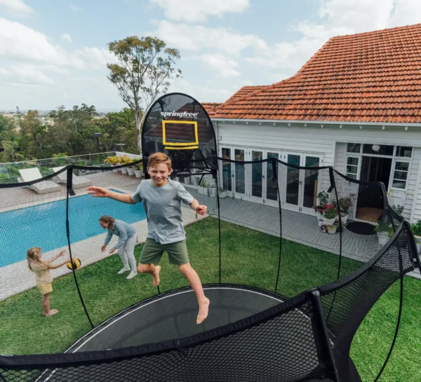 Trampolína Springfree R79 Medium Round se skákajícím chlapcem