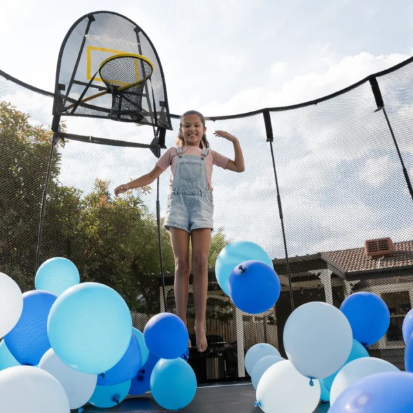 Dívka skáče s nafukovacími balóny na trampolíně Springfree